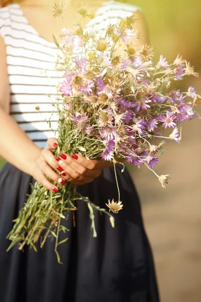 Frauenhände mit Blumenstrauß — Stockfoto