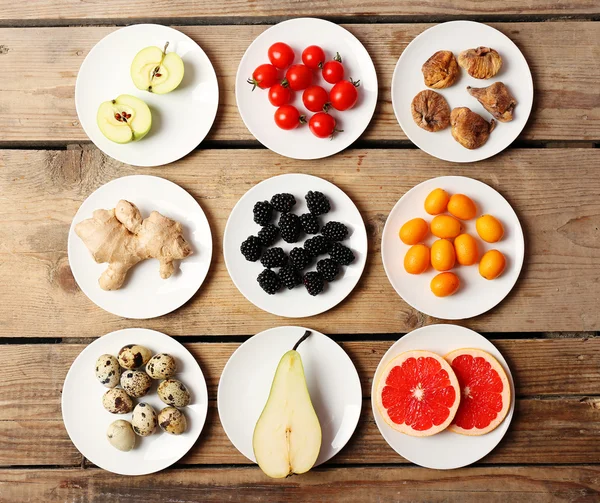 Different products on saucers on wooden table, top view — Stock Photo, Image