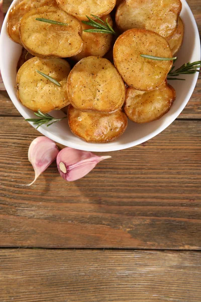 Deliziosa patata al forno con rosmarino in ciotola sul tavolo da vicino — Foto Stock