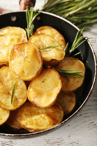 Lahodné pečené brambory s rozmarýnem v pánvi na stole zblízka — Stock fotografie