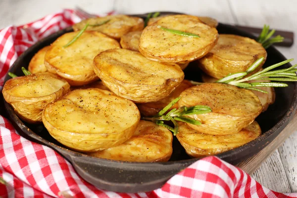 Läckra bakad potatis med rosmarin i stekpanna på bordet på nära håll — Stockfoto