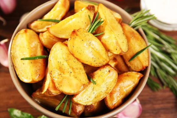 Cunei di patate al forno su tavolo di legno, primo piano — Foto Stock