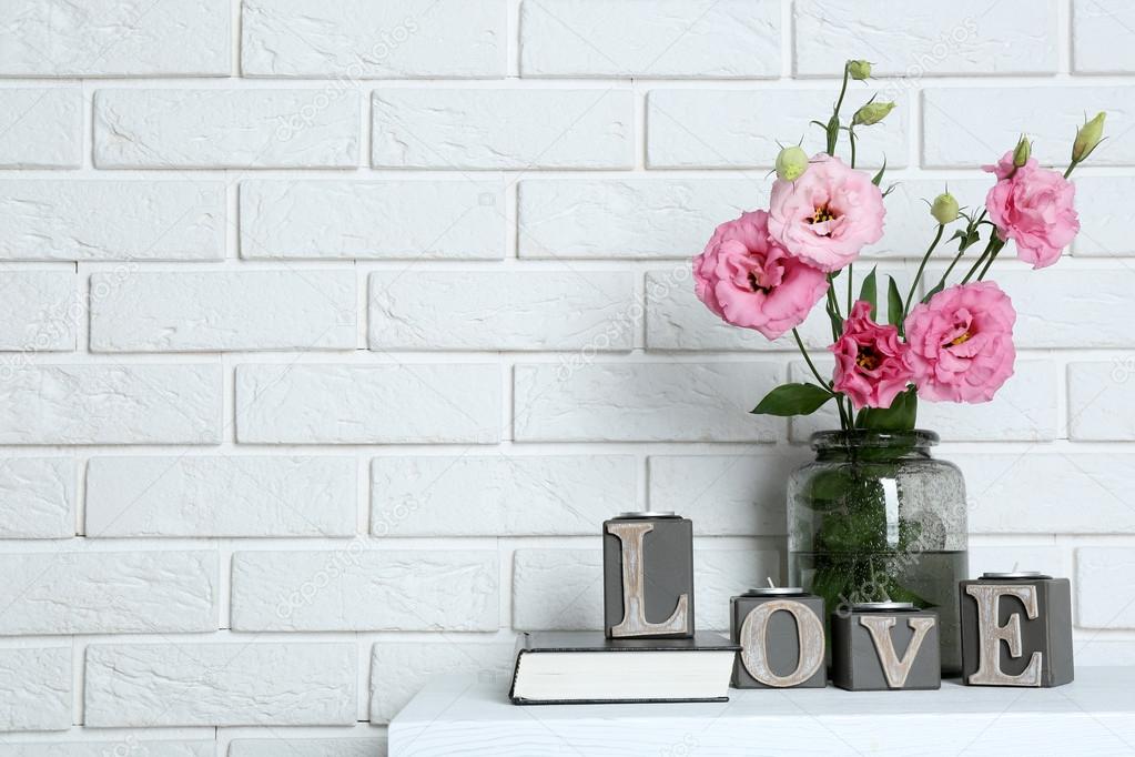 Beautiful flowers in vase with word Love 