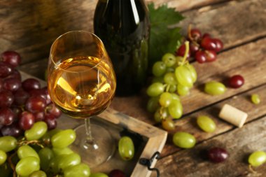 Beyaz ve kırmızı üzüm ahşap arka plan üzerinde şarap şişesi ile