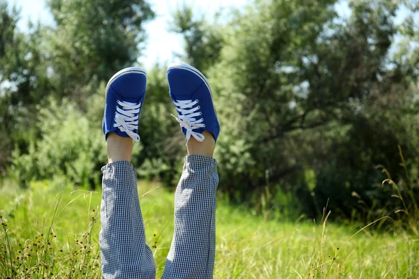 Frauenbeine in bunten Turnschuhen — Stockfoto