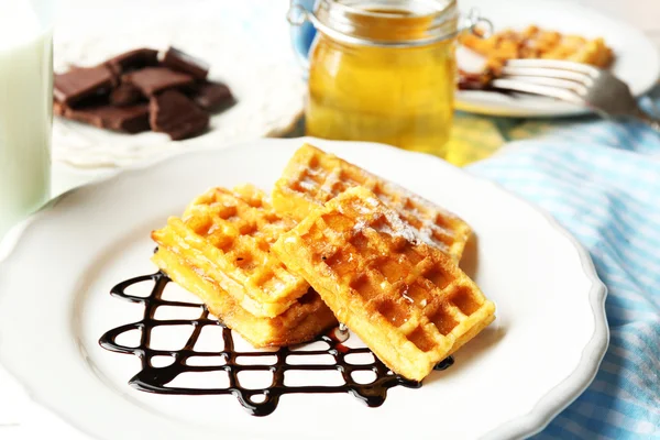 Doces waffles caseiros com molho de chocolate no prato, no fundo claro — Fotografia de Stock