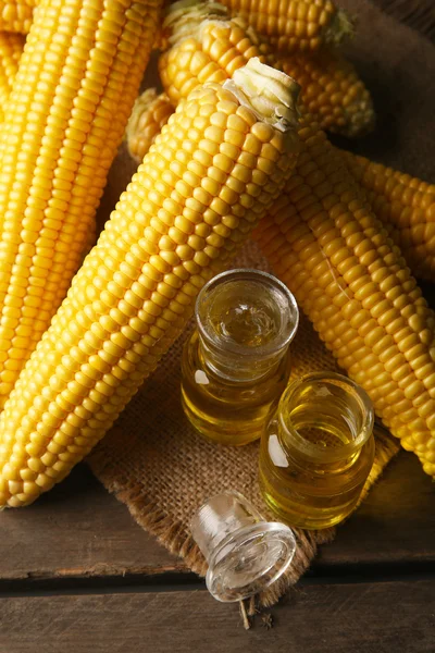 Maíz fresco con botellas de aceite en la mesa de cerca — Foto de Stock