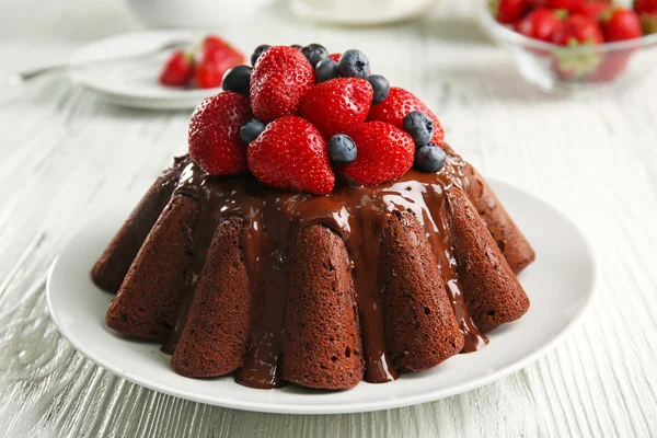 Köstliche Schokoladenkuchen mit Erdbeeren im Teller auf dem Tisch, Nahaufnahme — Stockfoto