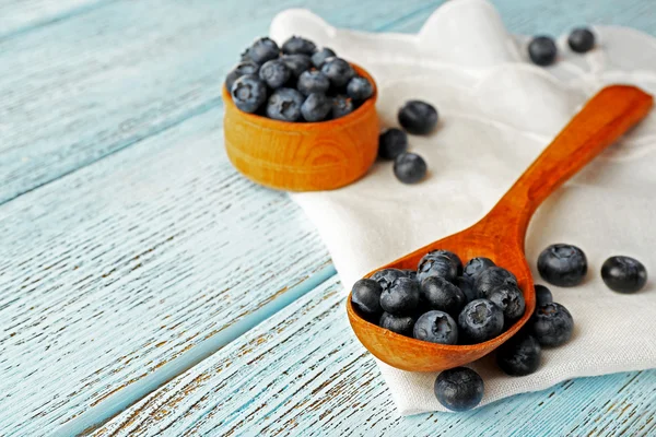 Bleuets frais dans une cuillère et un bol sur la table fermer — Photo