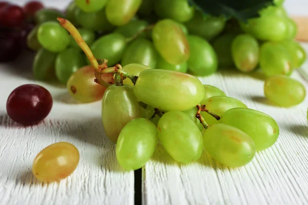 Белый и красный виноград на белом деревянном фоне — стоковое фото