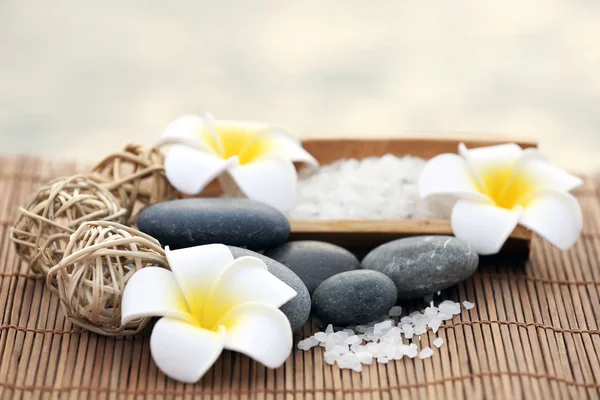 Çakıl taşları ve fragipani çiçek gerdanlı arka plan üzerinde kompozisyon