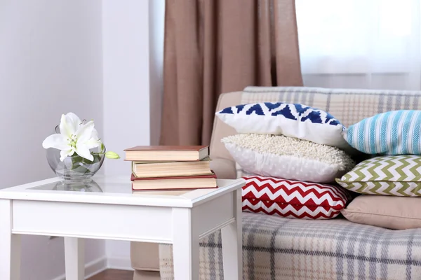 Диван с множеством красивых мягких подушек в номере — стоковое фото