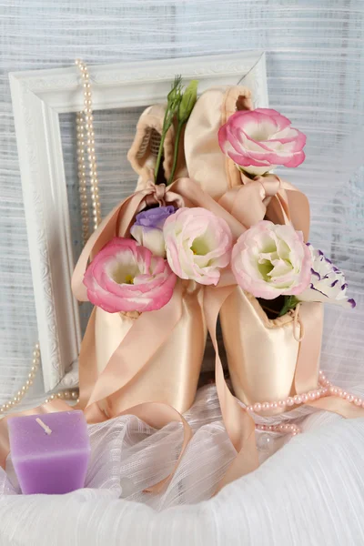 Decorated  ballet shoes with frame and flowers on satin background — Stock Photo, Image