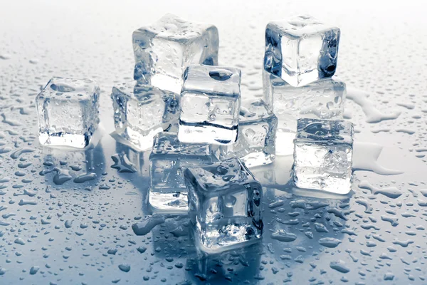 Cubes de glace fondus sur fond gris, gros plan — Photo
