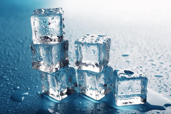 Derretimiento de cubitos de hielo colocados como escaleras con gotas alrededor, de cerca —  Fotos de Stock