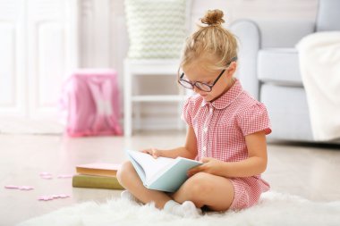 Küçük kız kitap okuyor.