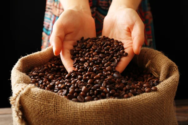 Händer i sac med rostade kaffebönor — Stockfoto