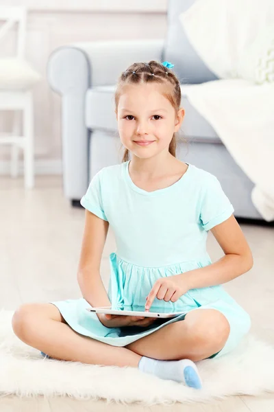 Kleines süßes Mädchen mit digitalem Tablet — Stockfoto