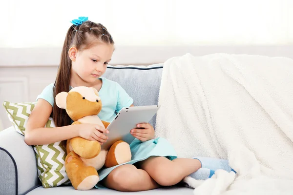 Meisje met teddybeer en tablet — Stockfoto