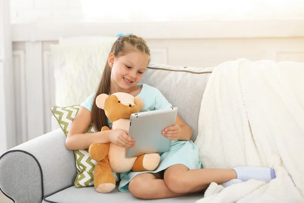 Petite fille avec ours en peluche et tablette — Photo
