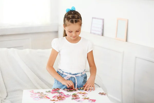 Милая маленькая девочка, играющая с головоломками — стоковое фото