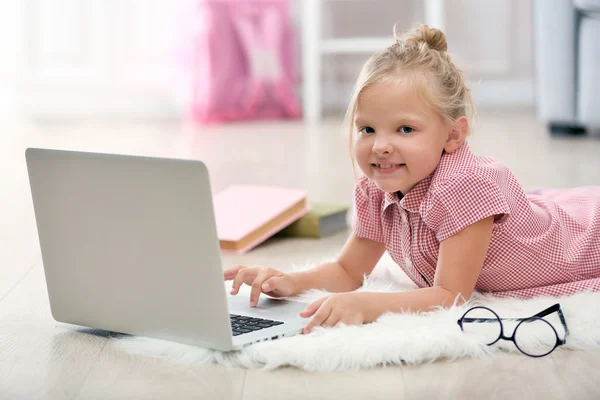 Klein meisje met laptop — Stockfoto