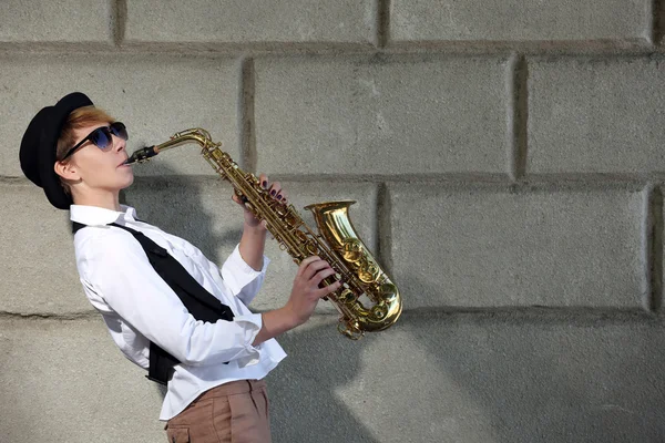 Attraktive Frau mit Hut spielt Saxofon — Stockfoto