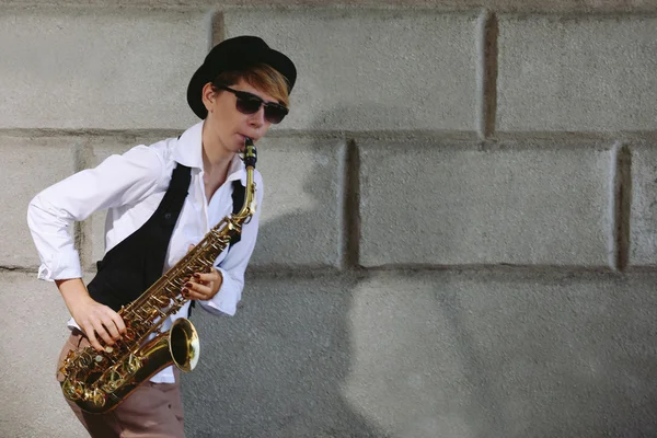 Mujer atractiva en sombrero toca saxofón — Foto de Stock