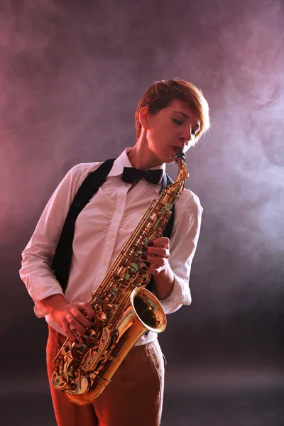 Женщина профессионально играет на саксофоне — стоковое фото