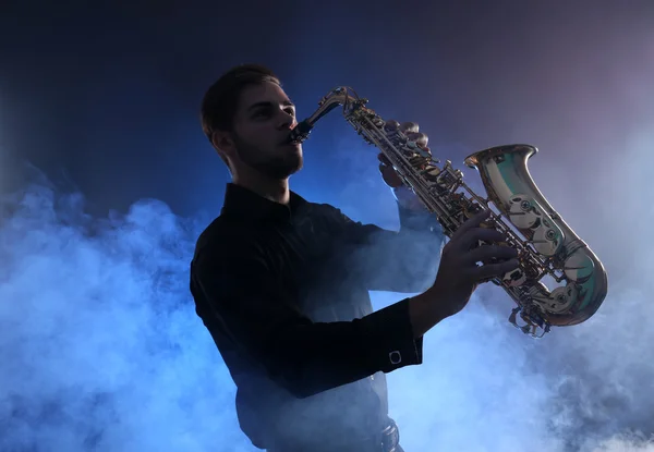 Elegante saxofonista toca jazz en humo azul — Foto de Stock