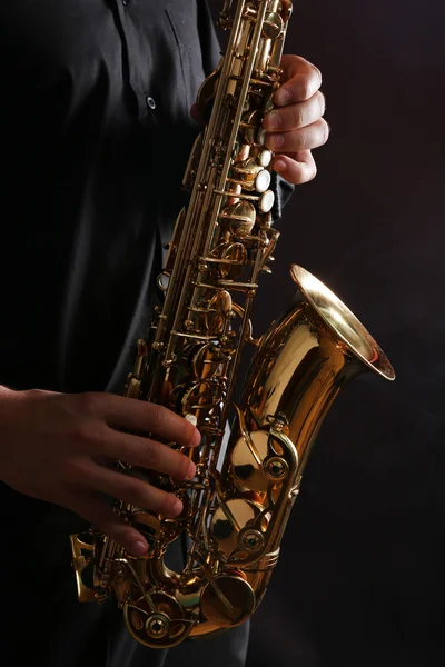 Músico em camisa preta com sax — Fotografia de Stock