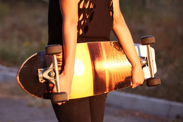 Jovem com placa de patinação — Fotografia de Stock