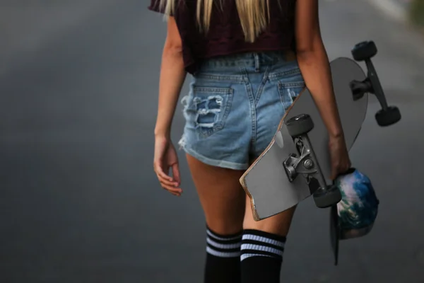 Jonge vrouw met schaatsen board — Stockfoto