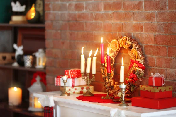 Christmas decorations and candles on mantelpiece — Stock Photo, Image