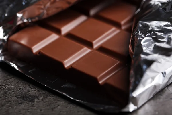 Čokolády v alobalu na šedém pozadí — Stock fotografie