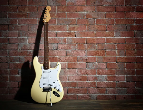 Kytara na cihlovou zeď pozadí — Stock fotografie