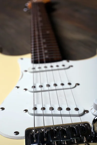 Elektrická kytara na dřevěné pozadí, zblízka — Stock fotografie