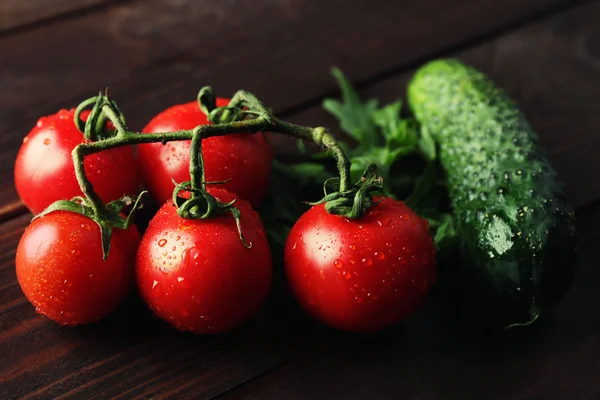 Tomatoes, cucumber and arugula on wooden background — Stock Photo, Image