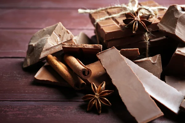 Svart choklad bitar med kryddor på trä bakgrund — Stockfoto