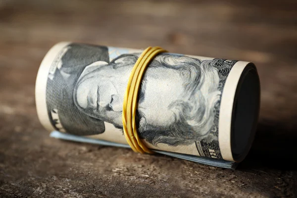 Dollars roll on wooden background — Stock Photo, Image