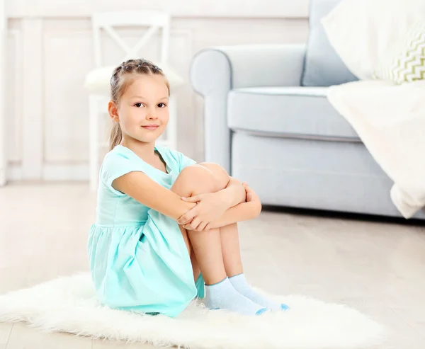 Petite fille mignonne assise sur le tapis Images De Stock Libres De Droits