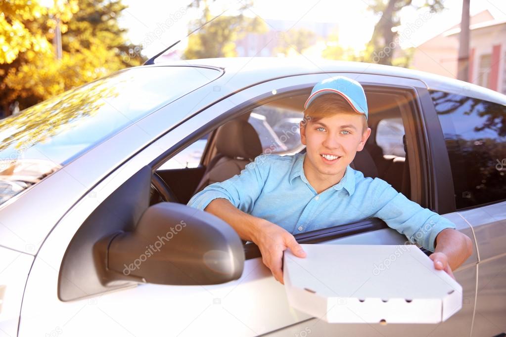 Pizza delivery boy in car