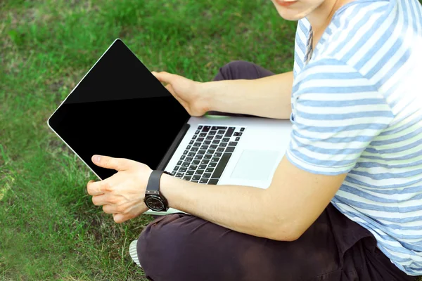 Jongeman met laptop buiten — Stockfoto