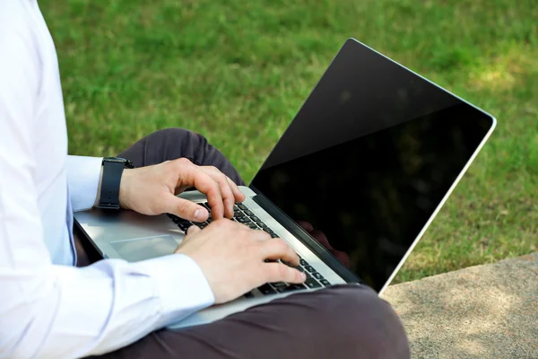 Jeune homme avec ordinateur portable à l'extérieur — Photo