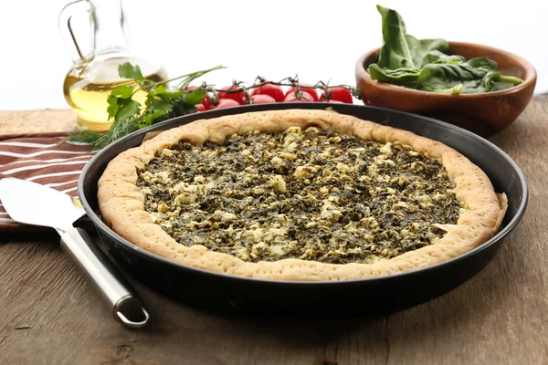 Open pie met spinazie en tomaat kers op tafel close-up — Stockfoto