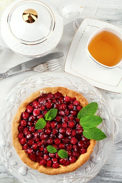 Taart met frambozen en smakelijke thee, op een houten achtergrond kleur — Stockfoto