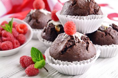 Çilek ve ahşap masa üzerinde taze nane ile lezzetli çikolata cupcakes yakın çekim