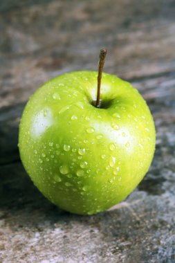 Ahşap masa üzerinde olgunlaşmış yeşil elma yakın çekim