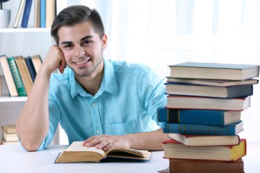 Genç adam masada kitap okumak