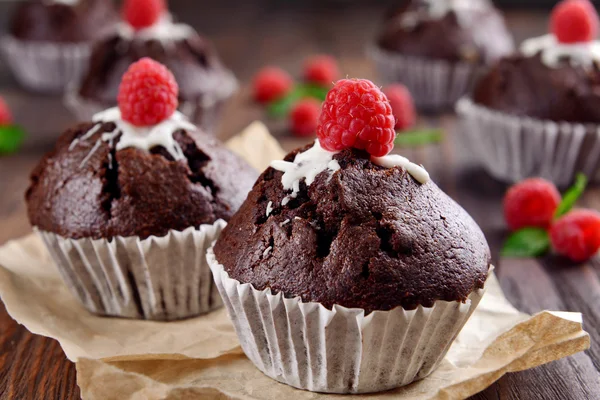 Deliciosos cupcakes de chocolate com bagas na mesa de perto — Fotografia de Stock